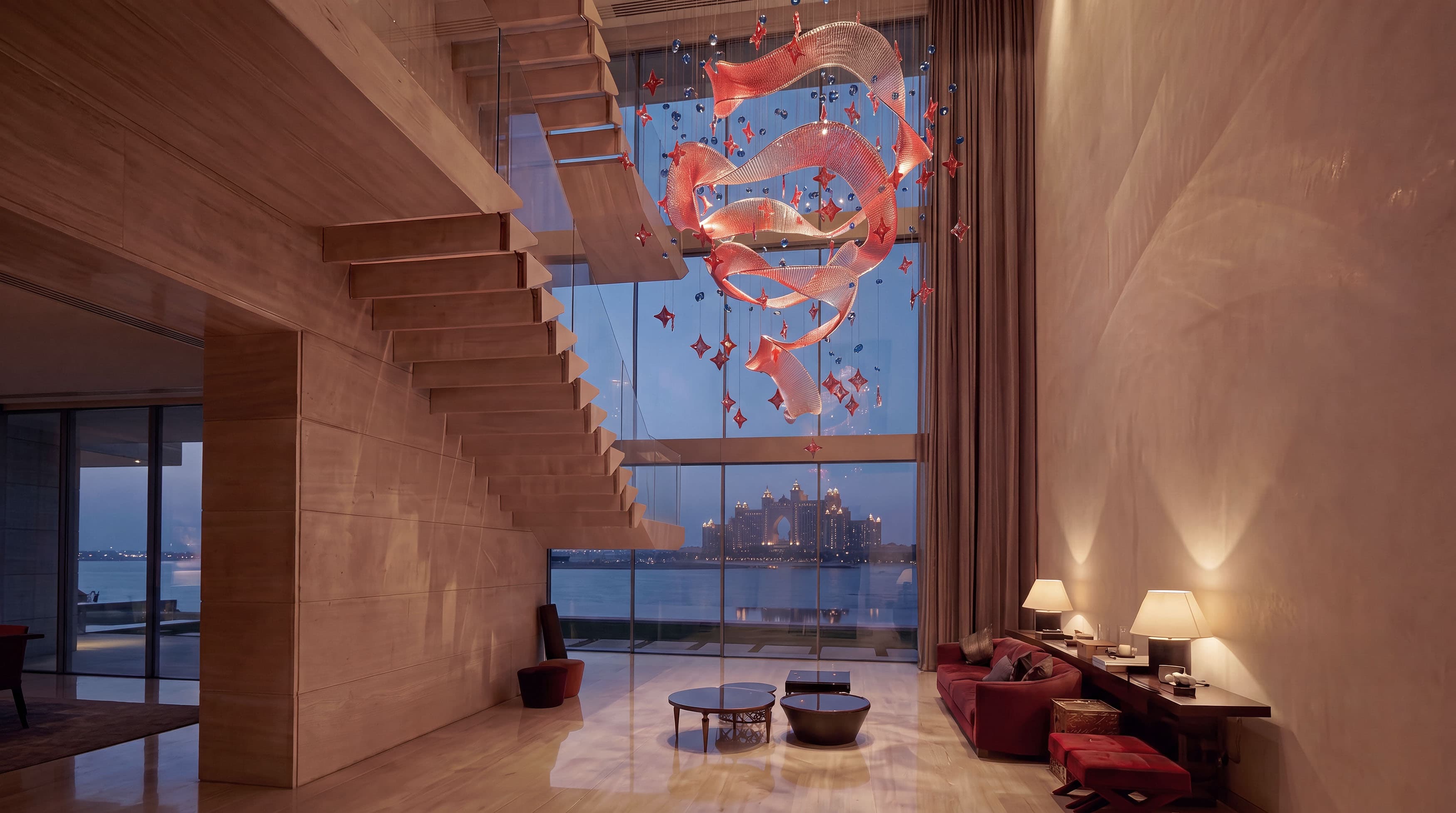 Crimson Orbit chandelier suspended beside a staircase in a Palm Jumeirah residence at night