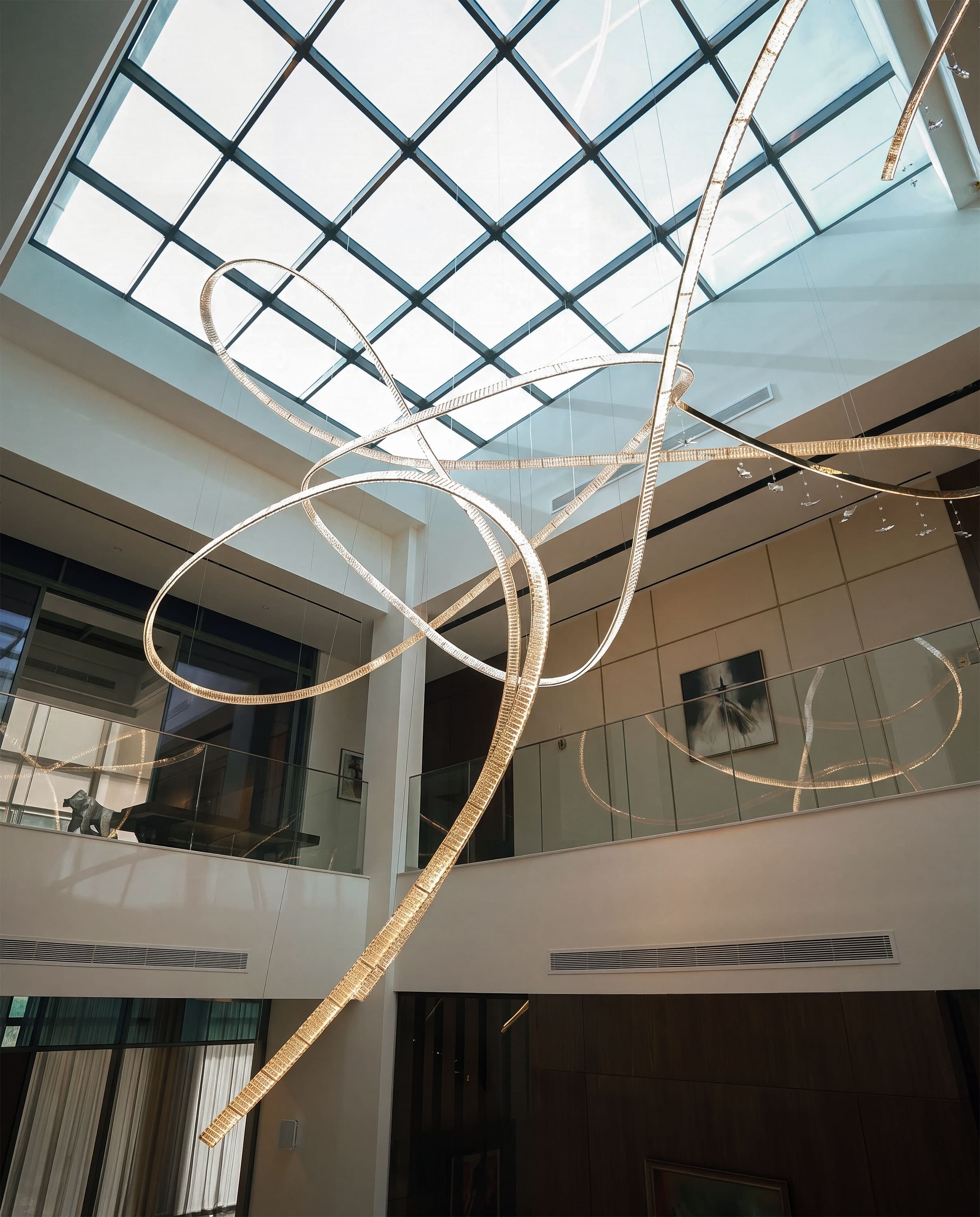 Bespoke illuminated chandelier installed beneath a skylight in a Dubai Hills Estate villa